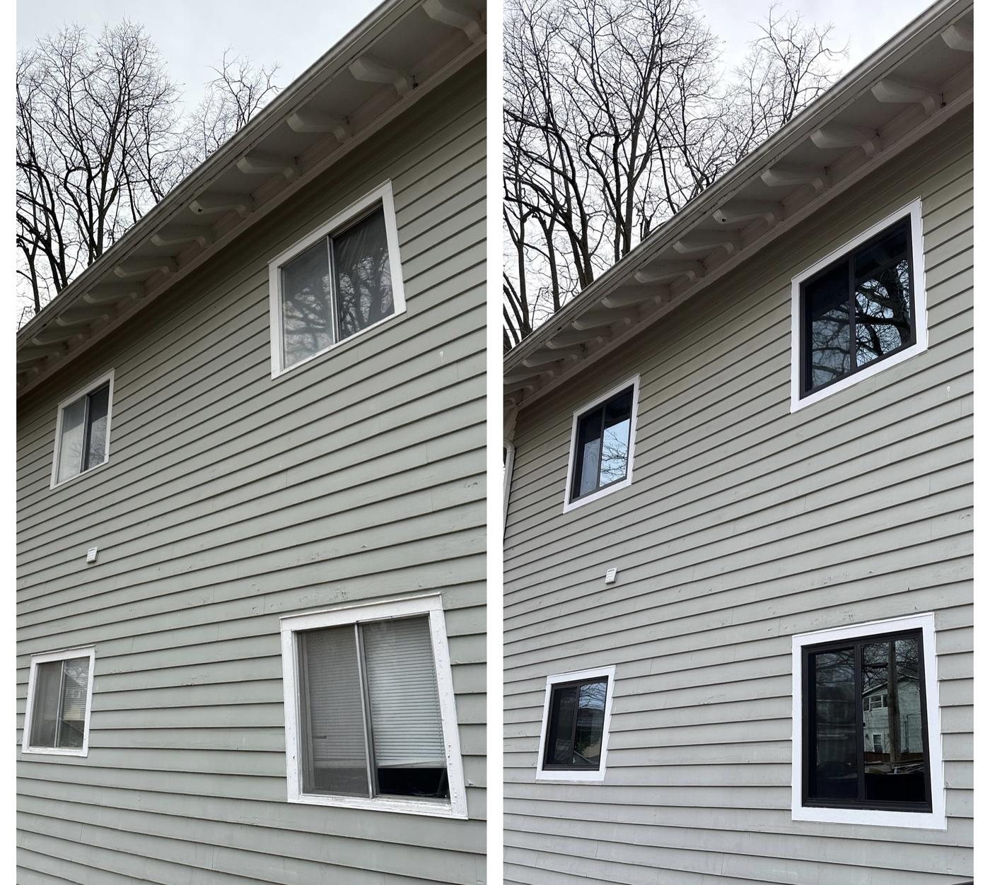 A genuine before and after: old worn white sliding windows on the left, new black-framed windows on the same two-story house on the right